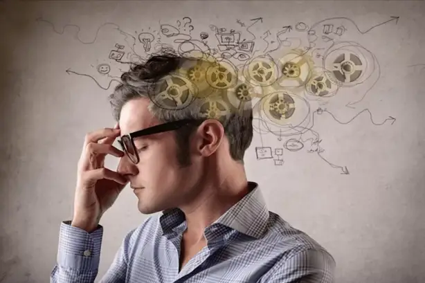 شخص يمسك برأسه نتيجة ضعف التركيز والتشتت الذهني بسبب نقص العناصر الغذائية
