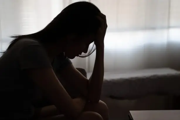 شاب يمسك رأسه من التوتر يعكس المعاناة اليومية مع الأوهام والهلوسة السمعية